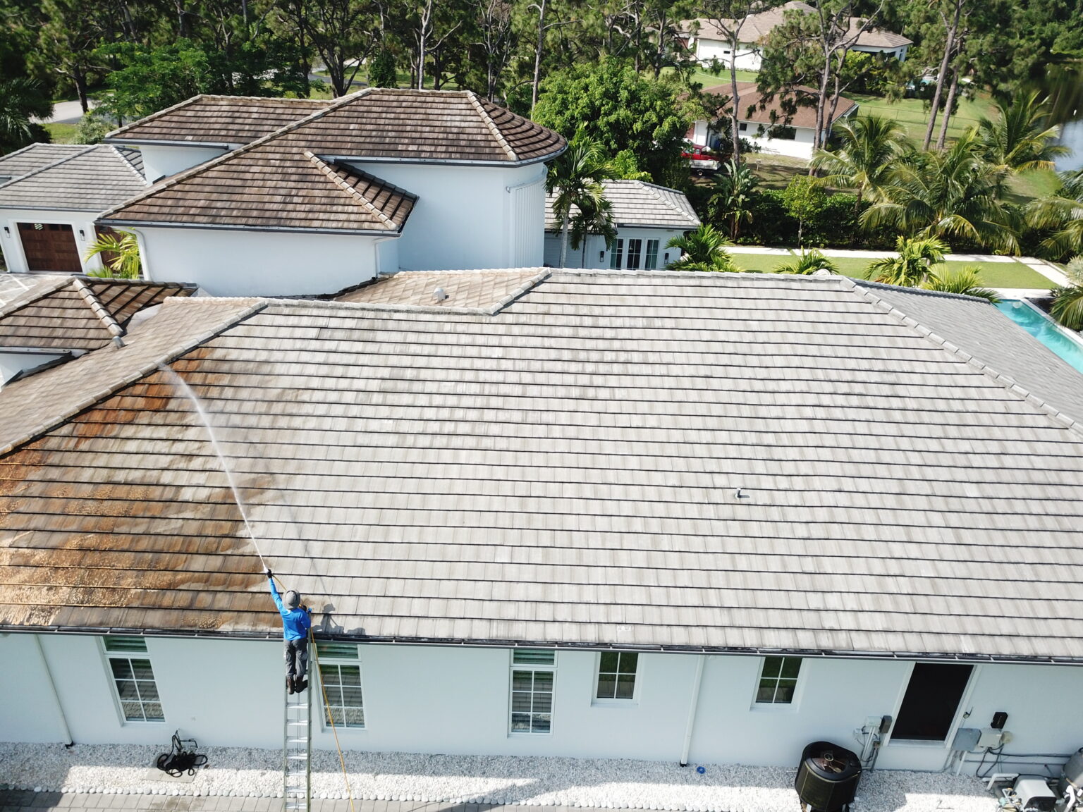 A person cleaning the roof of the house